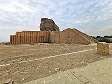 A large, partially restored, brick building with a soldier in front