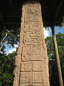 El lado de una estela, dividido en paneles cuadrados con jeroglíficos esculpidos