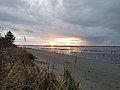 Sunset over a beach at low tide with land in the distance