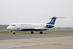 Fokker 100 v barvách Montenegro Airlines na mezinárodním letišti Domodědovo v Moskvě