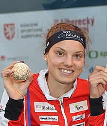 Aebersold holding a medal to the camera