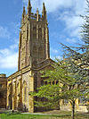 Yellow stone building with arched windows and ornate square tower.