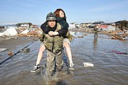 東日本大震災被災地で被災者を背負って移動する自衛官