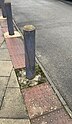 Wooden bollard painted grey, some paint is worn away