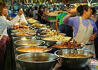 Un puesto de mercado en el mercado de Thanin en Chiang Mai, Tailandia, vendiendo comida preparada. Los puestos de mercado que venden alimentos se encuentran en todo el Sudeste Asiático.