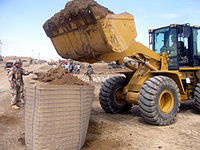 Ingenieros de Ejército iraquí llenan una sección de cuatro-pies HESCO MIL con un cubo loader.