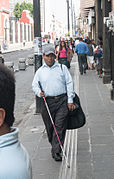 Blind man walking with a long cane.jpg