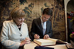 Angela Merkel en Mark Rutte ondertekenen het gastenboek, 23 mei 2013