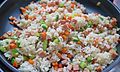 Stir-frying vegetable fried rice in a frying pan