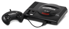 Consola de videojuegos negra con ranura de carga superior y controlador único con cable, panel direccional y cuatro botones