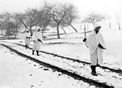 Amerikanische Soldaten mit aus weißen Laken improvisierter Schneetarnung während der deutschen Ardennenoffensive (1944)
