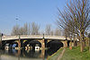 A curving iron bridge with three arches carried on sandstone piers