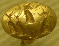 Anillo-sello de oro grabado con figuras femeninas.