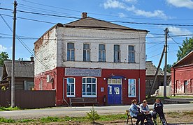 Photographie d'un immeuble en brique à deux étages, avec le rez-de-chaussée en briques blanches et l'étage en briques marrons