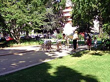 Photo en couleur de joueurs de boules dans un cadre verdoyant.