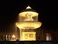 The fountains of Maderna and Bernini are lit up at night.