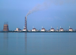 Blick von Westen auf das Kernkraftwerk Saporischschja mit den Blöcken 1 bis 6 (von rechts nach links). Die beiden hohen Kamine gehören zum Wärmekraftwerk Saporischschja, die beiden weißen Gebäude links von ihnen sind dessen Kesselhäuser. (Aufnahme von 2009)