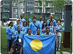 Quatorze personnes en bleu se tenant derrière un drapeau.