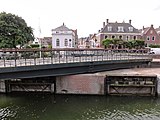 Geopende brug met witgepleisterde sluiswachterswoning