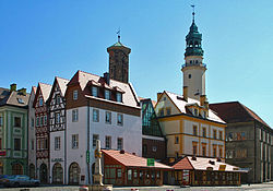 Zrekonstruovaný hlavní Rynek s radnicí ze 16. století, v popředí saský poštovní milník z 18. století.
