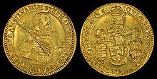 A golden coin depicting an armored middle-aged man on one side, and a coat-of-arms on the other side