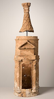 Photographie de la maquette en terre cuite d'un temple allongé. Le toit est séparé du reste du bâtiment.