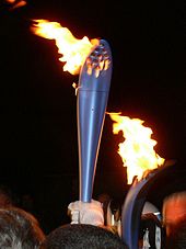 Photographie d'une torche allumée, de nuit.