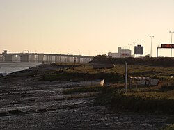 Pobřeží ostrova, v pozadí most přes záliv
