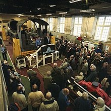 Durante una delle riunioni annuali di rendiconto i dirigenti dell'A1 Steam Locomotive Trust presentano a un gruppo di sottoscrittori le parti già costruite della locomotiva (cabina, telaio, rodiggio e camera a fumo). Officina dell'A1 Steam Locomotive Trust, 2004