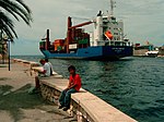 Een containerschip verlaat de haven van Curaçao.