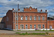 Photographie d'un bâtiment en briques rouges de deux étages.