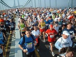 A crowd of runners crossing a bridge