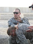 US Army 53441 BAGHDAD-San Benito, Tex. native, 1st Lt. Mike Olvera (top), manipulates Plant City Fla. native, Spc. David Croft's upper torso as he instructs Iraqi policemen in techniques for handling a physical con.jpg