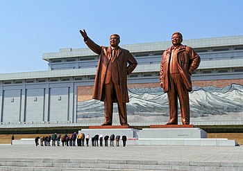 Návštěvníci projevující úctu severokorejským vůdcům Kim Ir-senovi a Kim Čong-ilovi, jejichž bronzové sochy dominují Velkému památníku Mansudae v Pchjongjangu