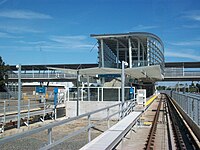 Approaching Sea Island Centre station from the west. Access to the station is via an elevated walkway above the tracks and adjacent roads.