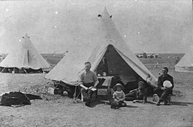 Three men and a child sitting in front of a tent during the North-West Resistance (1885), Moose Jaw, Saskatchewan (34407151225).jpg