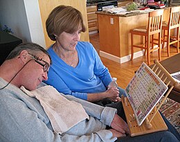 A man with ALS communicates with his wife by pointing to letters and words with a head mounted laser pointer.