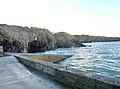 Falaises et grottes au sud-est du petit port de Cameros (situé au premier plan) à marée haute.