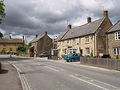 Street scene with a row of detached houses including a pub.