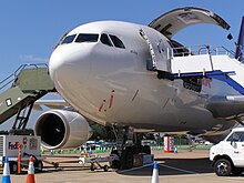 Avion au sol. Une grande porte cargo est ouverte du côté gauche.