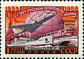 timbre à tons rose et orange, représentant un Tu-104 aux côtés d'un train et d'un navire cargo.