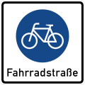 quadratisches Schild mit weißem Grund, darauf das Schild für Radweg (Fahrrad in blauem Kreis), darunter in schwarzer Schrift "Fahrradstraße"