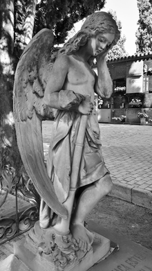 Escultura de un ángel doliente con tuba.