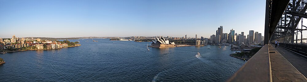 Sydney vidita de ponto Sydney Harbour Bridge, kun l'Opero-domo di Sydney centre.
