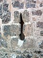 Detalle de tronera tipo «palo y orbe» en el muro frontal del castillo de Moya (Cuenca).