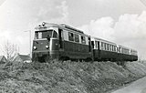RTM-loc MD 1807 'Scholekster' met rijtuigen 1522-1524, ex-NMVB (Belgische Buurtspoorwegen), onderweg vanaf de Spijkenisserbrug langs het Molenpad richting Spijkenisse; 17 maart 1963.