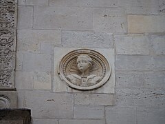 Photographie en couleur d'un détail sculpté sur la façade d'un bâtiment.