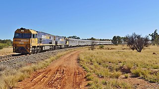 Train rounding a bend through scrubland