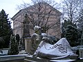 Künstlerisch gestaltetes Grab auf dem Gertrudenfriedhof in Oldenburg; im Hintergrund das Mausoleum der Großherzöge von Oldenburg