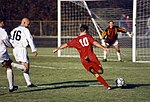 Un joueur attaquant (en maillot rouge) a passé la défense adverse (en blanc) et s'apprête à tirer. Le gardien de but va tenter d'empêcher le ballon d'entrer dans le but.